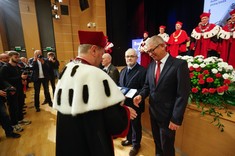 Uroczysta inauguracja roku akademickiego 2024/25. Rektor Piotr Koszelnik wręcza Robertowi Hanusowi medal za długoletnią wzorcową pracę.